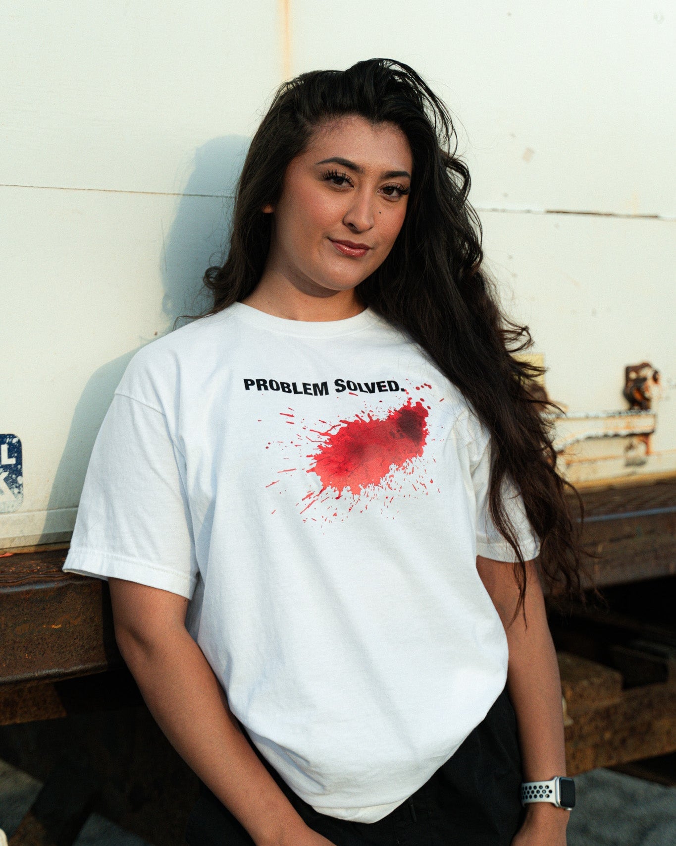Person wearing a white t-shirt with a red splatter design and text.